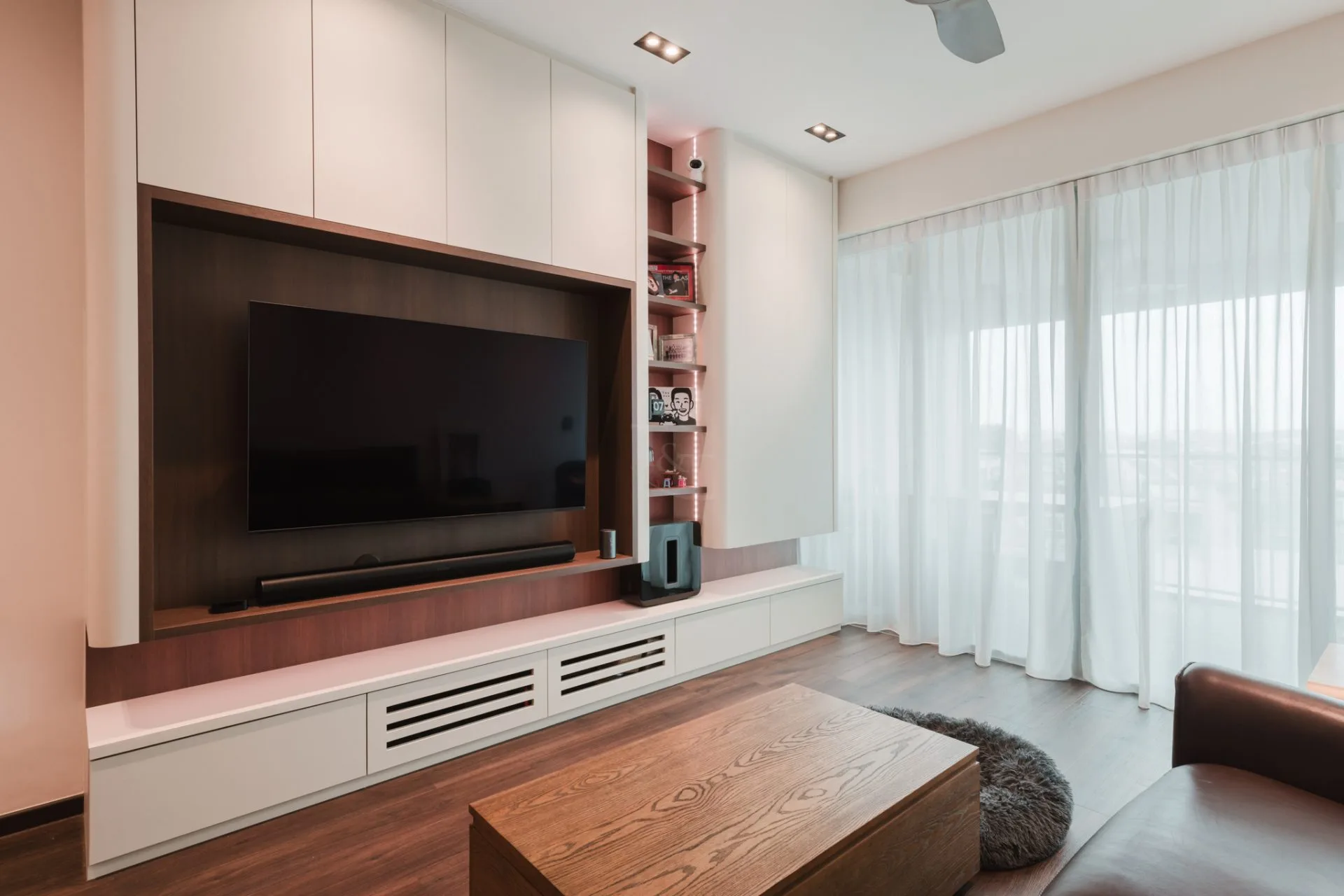 Modern TV feature wall with built-in cabinets and wooden accents.